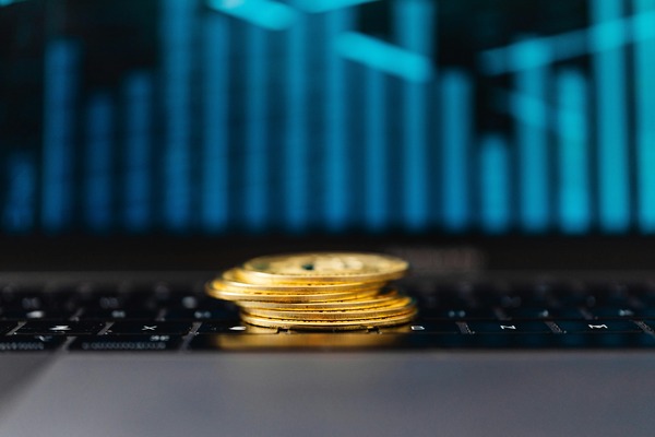 Gold cryptocurrency coins with a blue trading chart in the background