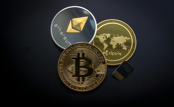 Ethereum (ETH), Bitcoin and Ripple cryptocurrency coins with a memory card
